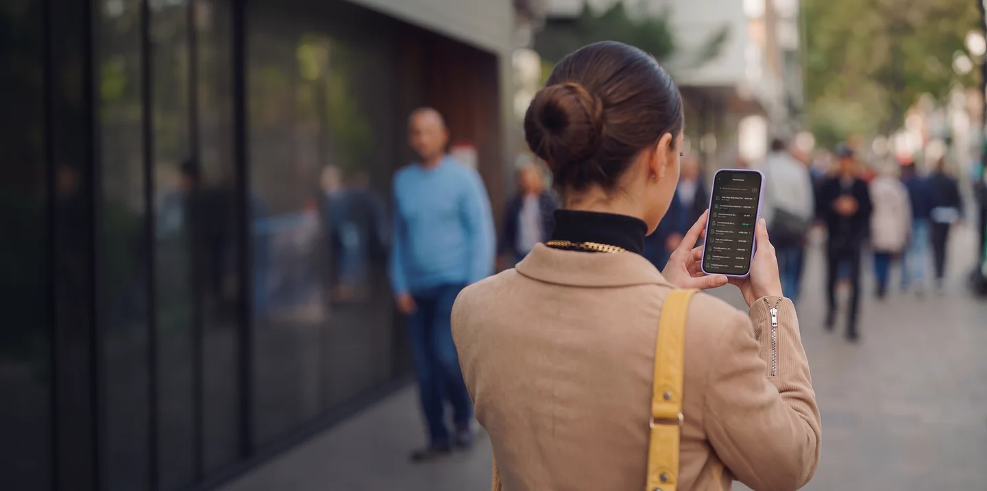 Persona revisando movimientos en su teléfono en la calle