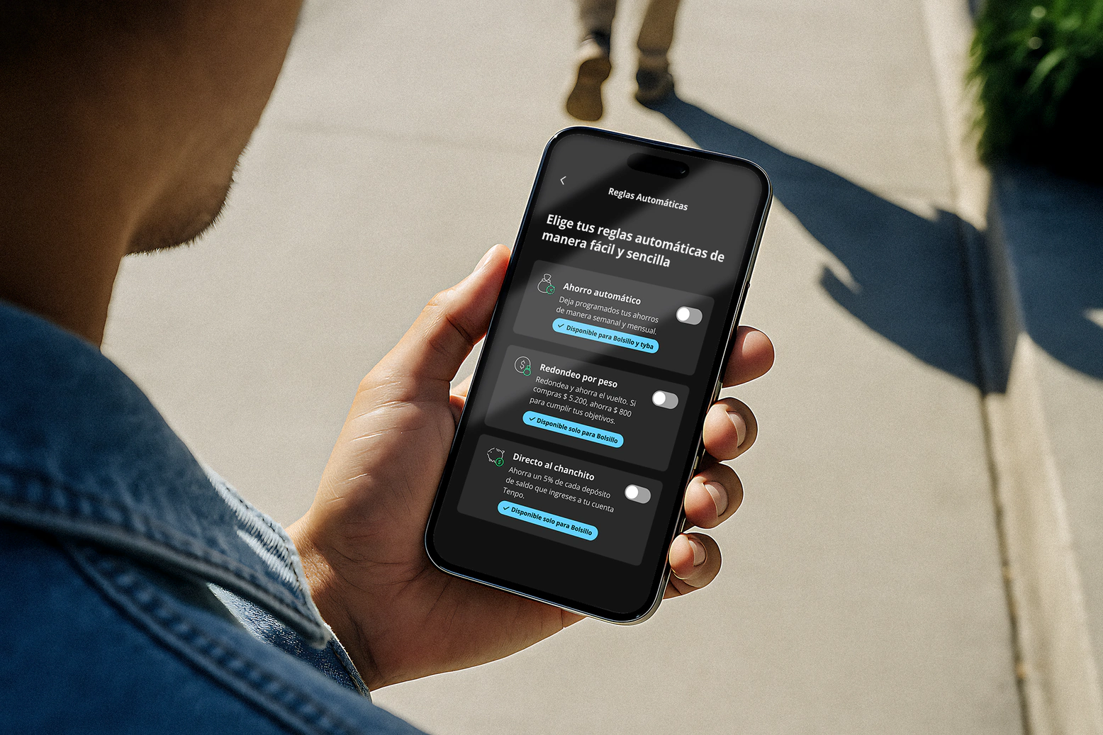 Mano sosteniendo un celular con la pantalla de Reglas Automáticas en la App Tenpo