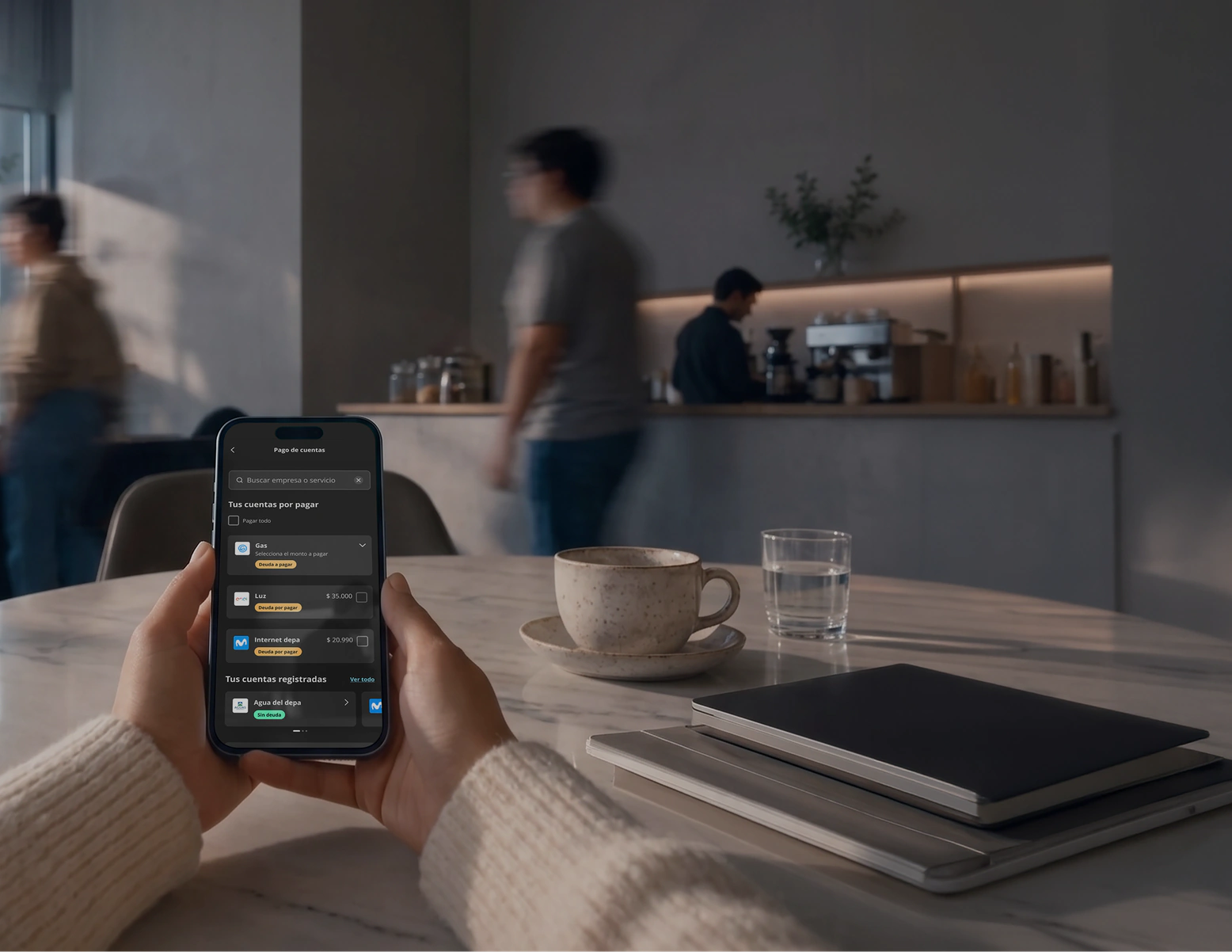 Usuario en una cafetería usando la App Tenpo para pagos de cuentas